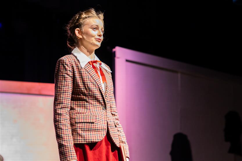 A student stands onstage